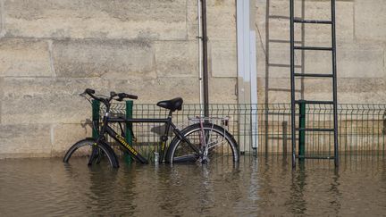 Un vélo, les roues dans l'eau, à cause de la crue de la Seine, à Paris, le 26 janvier 2018.&nbsp; (ST?PHANE ROUPPERT / CROWDPARK / AFP)