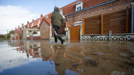 Une personne marche dans une rue inondée de Blendecques (Pas-de-Calais), le 7 novembre 2023. (JOHAN BEN AZZOUZ / MAXPPP)