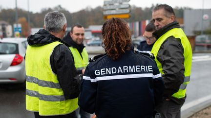 Un gendarme vérifie l'identité de&nbsp;personnes lors d'un barrage routier à Pont-de-Beauvoisin (Savoie), le 17 novembre 2018. Quelques heures plus tôt, une&nbsp;manifestante est morte après avoir été percutée par une automoboliste prise de panique à un barrage de "gilets jaunes".&nbsp; (ROMAIN LAFABREGUE / AFP)