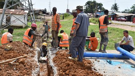 Installation d'une conduite d'eau potable dans un quartier de Monrovia au Liberia, le 12 octobre 2017. (ISSOUF SANOGO / AFP)