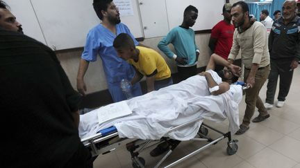 Un blessé est conduit en salle d'opération, le 10 novembre 2023, dans un hôpital de Gaza. (ADEL HANA/AP/SIPA)