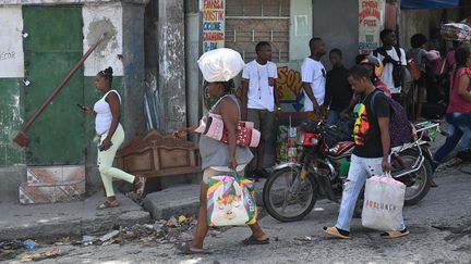 Des habitants de Carrefour-Feuilles, à Port-au-Prince (Haïti), évacuent le quartier, mardi 15 août 2023. (RICHARD PIERRIN / AFP)