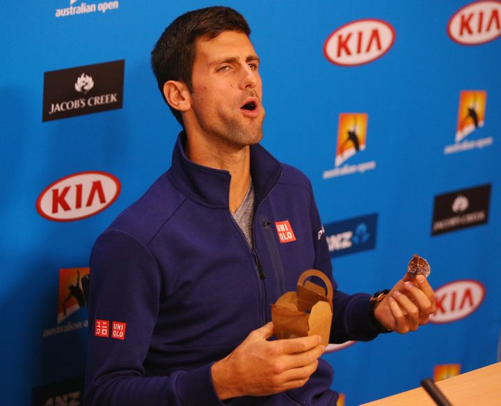 Le joueur de tennis serbe Novak Djokovic mange un chocolat lors d'une conférence de presse avant l'Open d'Australie, le 17 janvier 2016 à Melbourne. (MICHAEL DODGE / GETTY IMAGES ASIAPAC)