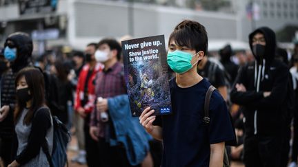 Un manifestant brandit une pancarte en soutient à la minorité ouïgour, à Hong-Kong, le 22 décembre 2019.&nbsp; (ANTHONY WALLACE / AFP)