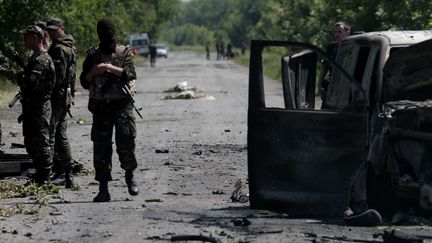 Des soldats ukrainiens inspectent le site d'une attaque s&eacute;paratiste pr&egrave;s du village de Blahodatne, dans l'est de l'Ukraine, le&nbsp;22 mai 2014. (IVAN SEKRETAREV / AP/ SIPA)