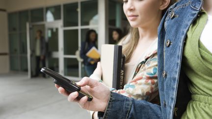 Trois adolescents sur quatre dorment avec leur t&eacute;l&eacute;phone portable allum&eacute; sous l'oreiller ou sur la table de chevet, selon une enqu&ecirc;te publi&eacute;e par l'Association sant&eacute; environnement France (ASEF). (ODILON DIMIER / ALTOPRESS / AFP)