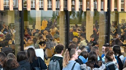 Des lycéens manifestent contre les épreuves communes de contrôle continu du baccalauréat tandis que d'autres attendent de passer leur examen, le 20 janvier 2020 au lycée René Cassin de Montfort-sur-Meu, en Ile-et-Vilaine (DAMIEN MEYER / AFP)