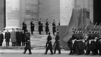 Le g&eacute;n&eacute;ral de Gaulle entour&eacute; de Georges Pompidou (&agrave; sa gauche), d'Andr&eacute; Malraux (&agrave; sa droite) et de nombreuses personnalit&eacute;s rendent hommage &agrave; Jean Moulin au Panth&eacute;on, le 19 d&eacute;cembre 1964. (AFP)