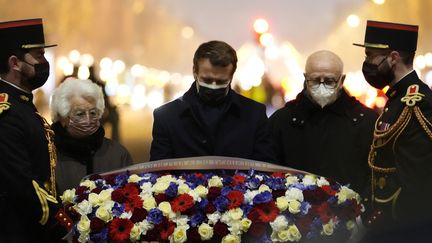 Emmanuel Macron ravive le 27 janvier 2022 la flamme sous l'Arc de Triomphe à Paris, en présence de deux rescapés de la Shoah : Esther Senot et Victor Perahia.
 (THIBAULT CAMUS / POOL / AFP)