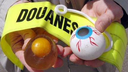 Un inspecteur des douanes pose avec des jouets dangereux, interdits de commercialisation en France depuis 2003, saisis &agrave; Saint-Nazaire (Loire-Atlantique)&nbsp;le 27 juin 2006. (FRANK PERRY / AFP)