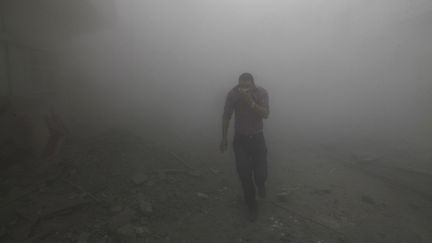 Un homme court dans une rue touch&eacute;e par des tirs de missiles, dans l'est de la Syrie, le 12 mars 2013. (REUTERS)