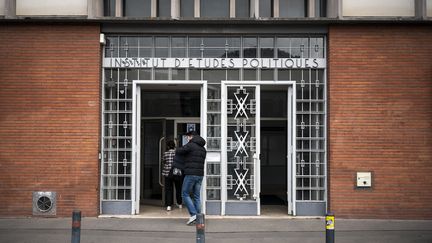 Deux personnes entrent dans les locaux de Sciences Po Toulouse, le 9 février 2021. (LIONEL BONAVENTURE / AFP)