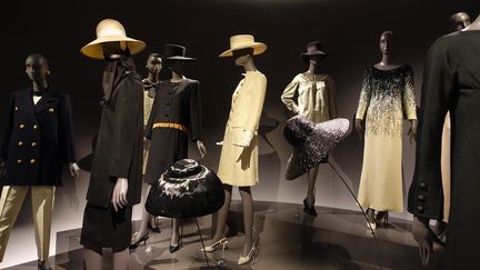 Dans cette alcove est rassemblée la garde-robe de la collection 1962 : pièces de jours, de cocktail et de soir déclinées ici en noir et blanc avec leurs accessoires. En face de ces vêtements, une vitrine retrace le parcours nécessaire à la réalisation d'une collection. A chaque saison de haute couture, Yves Saint Laurent réalise ses croquis au Maroc, puis les distribue aux ateliers, choisit les tissus. Chaque modèle est reproduit sur une fiche d'atelier. Des planches constituent ces "Bibles" qui donnent une vue d'ensemble du défilé. 
 (Corinne Jeammet)