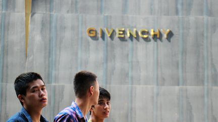 Des habitants marchent devant la boutique Givenchy à Chongqing, en Chine, en 2015.&nbsp; (HE LILI / IMAGINECHINA)