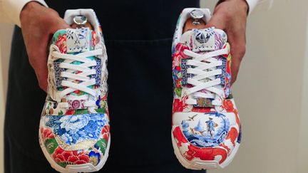 La paire de baskets unique conçue par Adidas et Meissen, présentée à New York chez Sotheby's, le 4 décembre 2020. (KENA BETANCUR / AFP)