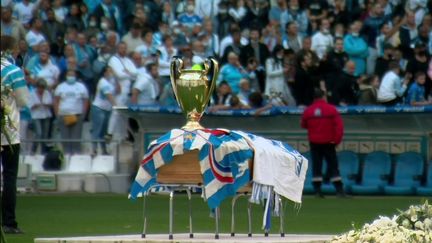 Les supporters de l'Olympique de Marseille ont fait leurs adieux à Bernard Tapie, jeudi 7 octobre, au stade Vélodrome de Marseille (Bouches-du-Rhône). Le cercueil du "Boss" a été placé au centre du terrain durant la cérémonie d'hommage.&nbsp; (CAPTURE D'ÉCRAN FRANCE 3)