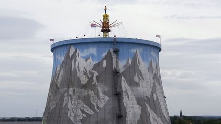 Sur la paroi de la tour de refroidissement où est peint un paysage alpestre, un mur d'escalade est érigé pour les alpinistes en herbe. (AFP PHOTO / PATRIK STOLLARZ)