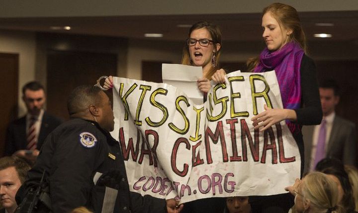 Manifestation anti-Kissinger à Washington en 2015. Les manifestants portent une banderole sur laquelle on peut lire «Kissinger criminel de guerre»