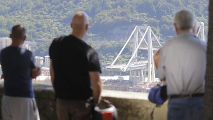 Le 15 août 2018, des habitants de Gênes (Italie) observent le pont qui&nbsp;s'est effondré la veille, faisant au moins 39 victimes. (MAXPPP)