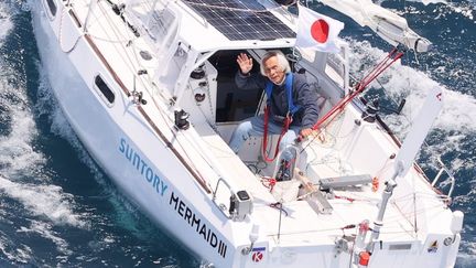 Kenichi Horie salue depuis son bateau, le 4 juin 2022, au terme d'une traversée du Pacifique, au large de Wakayama (Japon). (KEN SATOMI / YOMIURI / AFP)