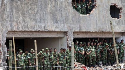 Des soldats prient dans les d&eacute;combres de l'immeuble effondr&eacute; &agrave; Savar&nbsp;(Bangladesh) en m&eacute;moire des 1 127 victimes, le 14 mai 2013. (A.M. AHAD / AP / SIPA)