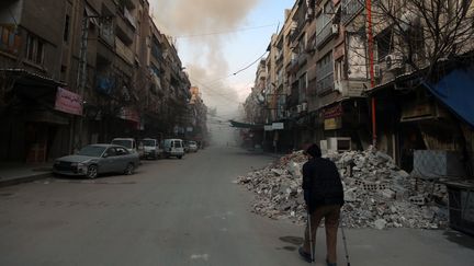 Un Syrien se promène dans la ville de Douma, dans la région assiégée du Ghouta orientale, à la périphérie de Damas (Syrie), le 23 février 2018. (HAMZA AL-AJWEH / AFP)