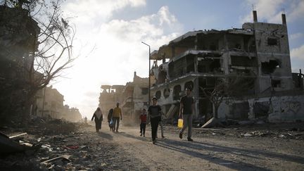 Des Palestiniens marchent dans les rues d&eacute;truites, le 6 ao&ucirc;t 2014 &agrave; Gaza.&nbsp; (FINBARR O'REILLY / REUTERS)