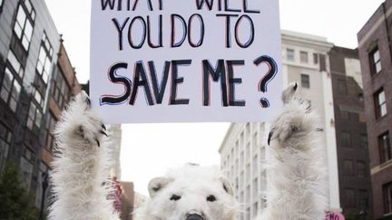 Un militant écologiste à Cleveland (Ohio) près d'un site républicain, le 18 juillet 2016. Tous les regards sont tournés vers l'Amérique, où le nouveau président Donald Trump a décrit le réchauffement climatique comme un «canular» et a déclaré en mai qu'il «annulerait» l'accord de Paris sur le réchauffement climatique s'il était élu chef du monde libre. (JIM WATSON / AFP)