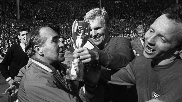 Le s&eacute;lectionneur anglais Alf Ramsey c&eacute;l&egrave;bre la victoire de son &eacute;quipe en Coupe du monde avec ses joueurs Bobby Moore (au centre) et Nobby Stiles (&agrave; droite), le 30 juillet 1966, &agrave; Londres (Royaume-Uni). (KEYSTONE / GETTY IMAGES )