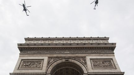 Des hélicoptères survolent l'Arc de Triomphe, mercredi 11 juillet, lors des répétitions du défilé du 14-juillet (ERIC FEFERBERG / AFP)