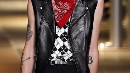 La fashion week s'est achevée avec la présentation de la collection très rock d'Hedi Slimane. En janvier, pour sa première collection masculine chez Saint Laurent, Hedi Slimane avait rendu hommage au grunge, cette fois, les looks sont ceux d'un rockeur. On s'imagine dans les années 70 ou 80, avec David Bowie notamment. Les pantalons, qu'il s'agisse de jean, de cuir, qu'ils soient noirs ou rouges brillants, sont skinny, tout près du corps. Les mannequins en noir portent ces pantalons qui arrivent juste au-dessus des chevilles avec des bottines pointues. Les vestes retiennent l'attention : veste de smoking revisitées, veste de costume plus classiques, de différentes longueurs. "C'est très beau, très rebelle, très rock. Et à même temps, ça reste élégant. C'est dans la veine de Saint Laurent", a dit Pierre Niney, qui interprète Yves Saint-Laurent dans un biopic dont le tournage a démarré vendredi. "J'ai bien aimé", a confié le couturier Azzedine Alaïa avant d'ajouter : "Chaque silhouette a un style particulier. Je vois les codes de Hedi" Slimane, a-t-il poursuivi. 
 (P.Kovarik / AFP)