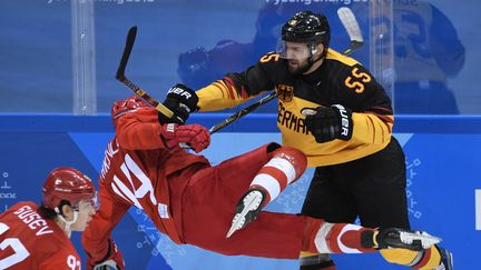 Choc violent en finale de hockey entre l'Allemand&nbsp;Felix Schutz (à droite)&nbsp;et le Russe&nbsp;Yegor Yakovlev (à gauche). L'équipe russe a finalement dominé l'Allemagne 4-3 et remporte un nouveau titre olympique, 26 ans après le dernier. (JUNG YEON-JE / AFP)