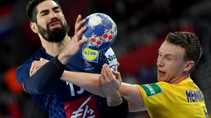 Nikola Karabatic bien pris par le Suédois Philip Henningsson (ANDREJ ISAKOVIC / AFP)