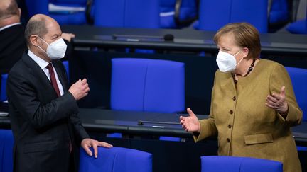 Olaf Schuolz (à gauche),&nbsp;vice-chancelier et ministre des Finances allemand et Angela Merkel, chancelière, au parlement allemand, le 28 janvier 2021. (BERND VON JUTRCZENKA / DPA)