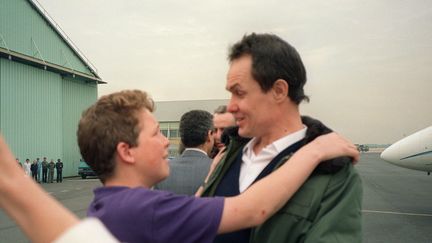 Jean-paul Kaufmann, à son retour du Liban le 5 mai 1988, tombe dans les bras de son fils de 14 ans qu'il n'a pas vu depuis trois années. (PASCAL GEORGE / AFP)