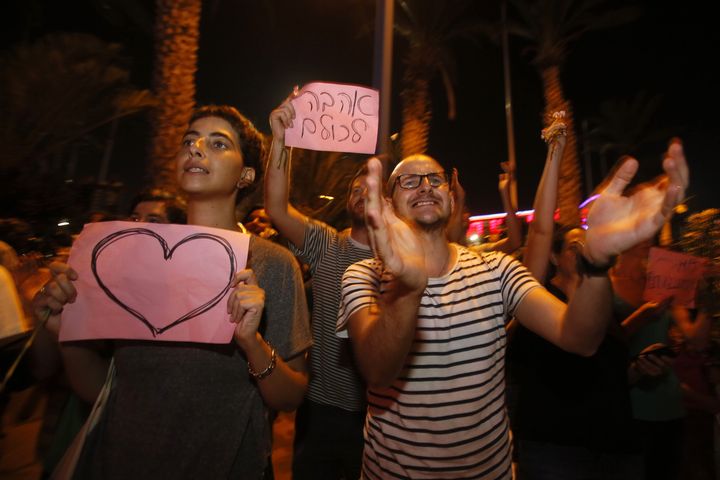 Les supporteurs des mari&eacute;s ont brandi des pancartes soutenant les deux amoureux.&nbsp; (GALI TIBBON / AFP)