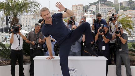 Le ma&icirc;tre de c&eacute;r&eacute;monie, Lambert Wilson, ne se fait pas prier pour la s&eacute;ance photos, multipliant les contorsions. (REGIS DUVIGNAU / REUTERS)