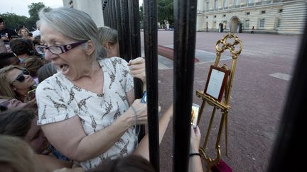 Hyst&eacute;rie, devant Buckingham Palace &agrave; Londres, apr&egrave;s la pose sur un chevalet de la missive annon&ccedil;ant la naissance du Royal Baby le 22 juillet 2013.&nbsp; (NEIL HALL / REUTERS)