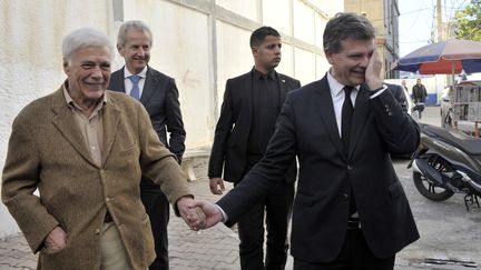 Guy Bedos tient la main d'Arnaud Montebourg, le 11 décembre 2016, à Alger (Algérie). (RYAD KRAMDI / AFP)