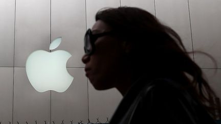 Une femme passe devant un magasin Apple &agrave; San Francisco (Californie), le 10 juillet 2013. (JUSTIN SULLIVAN / GETTY IMAGES NORTH AMERICA)