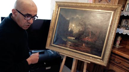 &nbsp; (Ahmed Ziani et le tableau qu'il a acheté sur Le Bon coin. Un Renoir, d'après lui. © MaxPPP)