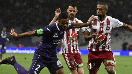 Le défenseur de Toulouse Kelvin Amian à la lutte avec deux joueurs d'Ajaccio en barrage de promotion-relégation, dimanche 27 mai à Toulouse (Haute-Garonne). (PASCAL PAVANI / AFP)