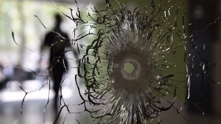 Un impact de balle sur une vitrine des Champs-Elysées, photographié le 21 avril 2017, au lendemain de l'attentat perpétré à Paris. (PHILIPPE LOPEZ / AFP)