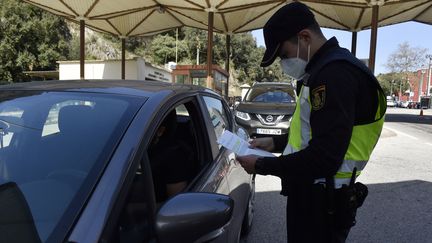 Un policier espagnol contrôle les tests PCR des automobilistes à la frontière franco-espagnole au Perthus (Pyrénées-Orientales) le 30 mars 2021 (RAYMOND ROIG / AFP)