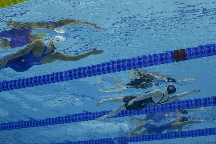 La Française&nbsp;Emma Terebo (à gauche), la Néerlandaise Maaike de Waard (centre), et la Suédoise&nbsp;Hanna Rosvall, lors de la demi-finale du 100 mètres dos, le 19 juin 2022, aux Mondiaux de Budapest (Hongrie). (OLI SCARFF / AFP)