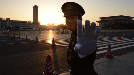 Un policier chinois tente d'emp&ecirc;cher un photographe d'immortaliser la place Tiananmen (P&eacute;kin), le 8 novembre 2012. (MARK RALSTON / AFP)