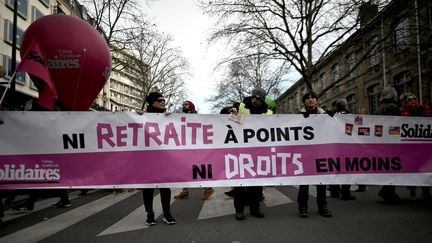 Des manifestants tiennent une banderole contre la réforme des retraites, le 11 janvier 2020 à Paris, lors d'une journée interprofessionnelle de mobilisation. (LIONEL BONAVENTURE / AFP)