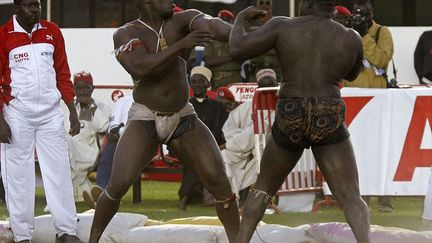 Ce combat est un duel de champions. Yakhya Diop Yekini contre Mohamed Ndao Tyson. En 2006, les deux lutteurs se rencontrent pour la première fois et Yekini remporte le match. Entre 1997 et 2012, ce dernier n’a pas perdu un seul combat. C’est en 2016 qu’il a décidé de prendre sa retraite. Son bilan: 22 combats, 19 victoires. Face à lui, Tyson, qui porte le même nom que le boxeur américain, est une star de la lutte des années 1990. Pour le sociologue du sport Abdou Wahid Kane, Tyson «incarne la tradition et la modernité».  (REUTERS/Finbarr O&#039;Reilly)