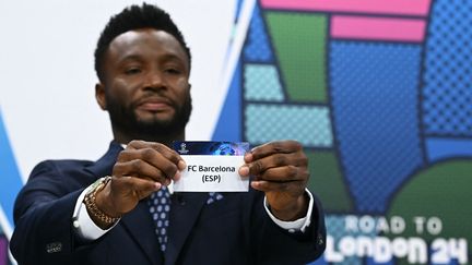 L'ancien joueur de Chelsea John Obi Mikel tire le nom du FC Barcelone comme adversaire du PSG en quarts de finale de la Ligue des champions, le 15 mars 2024 à Nyon (Suisse). (FABRICE COFFRINI / AFP)