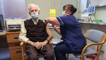 Un homme reçoit une dose de vaccin contre le coronavirus, le 14 décembre 2020, à Londres, au Royaume-Uni. (STEVE PARSONS / AFP)